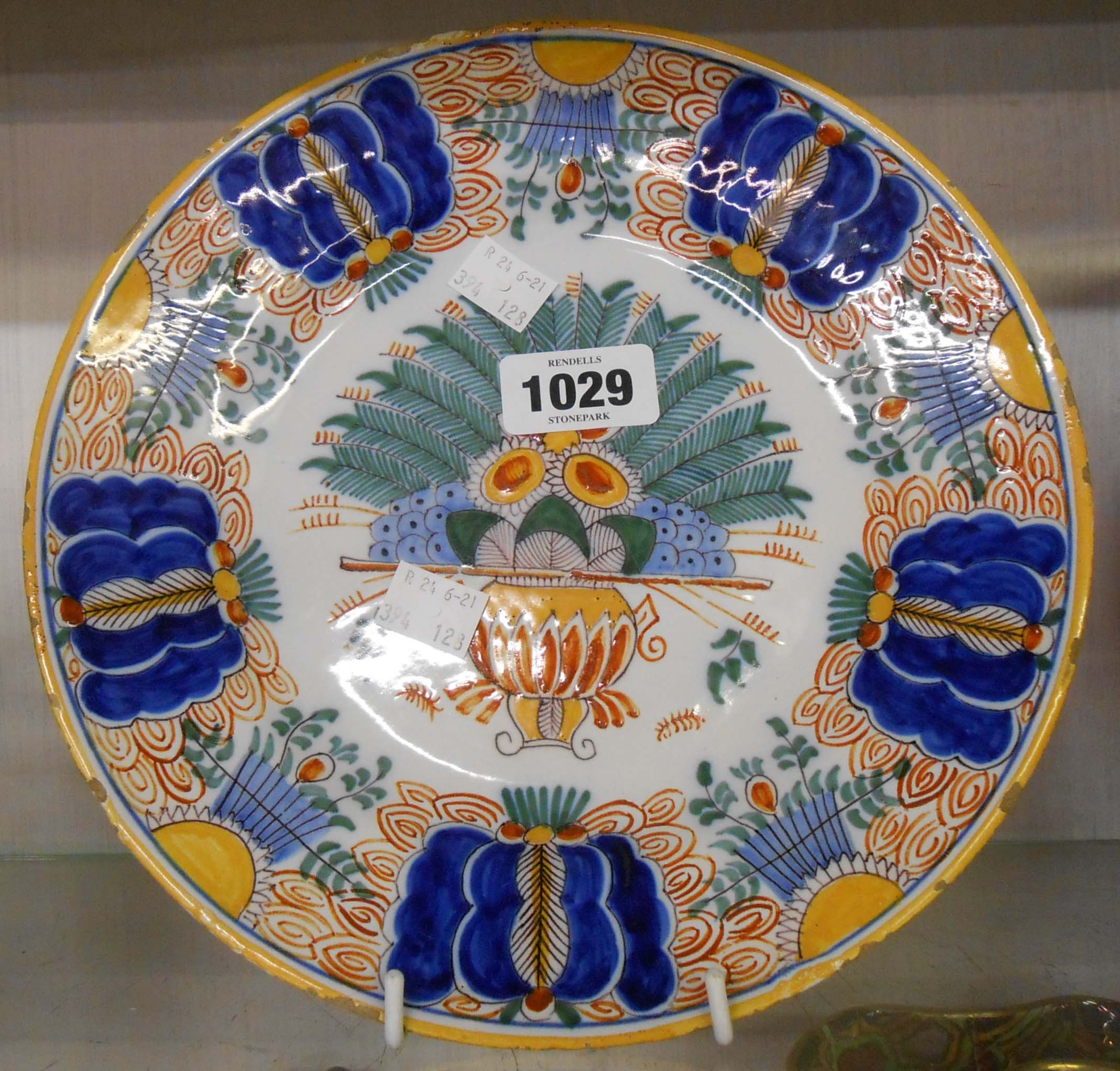 An 18th Century Dutch Delft plate hand painted in polychrome with a large central floral urn