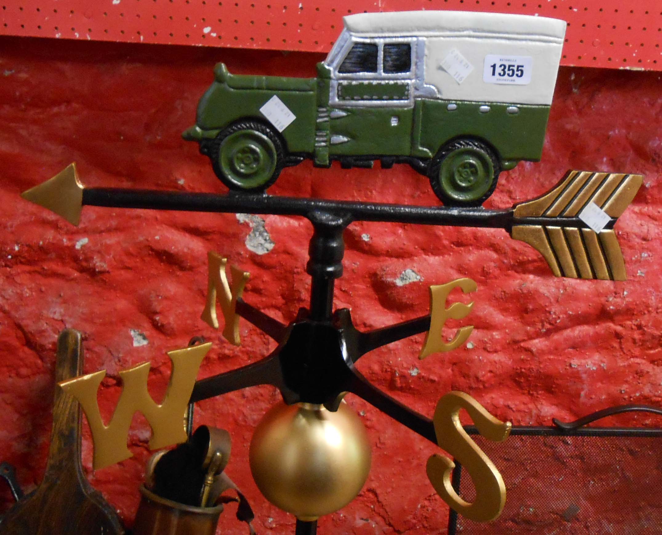 A modern cast metal weather vane with a Land Rover finial