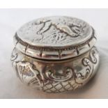 An antique Dutch silver circular box with hinged lid, embossed decoration and remains of parcel gilt