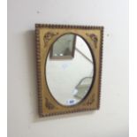 A vintage small gilt framed wall mirror with applied decoration and oval plate