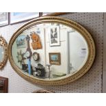 An early 20th Century gilt framed bevelled oval wall mirror