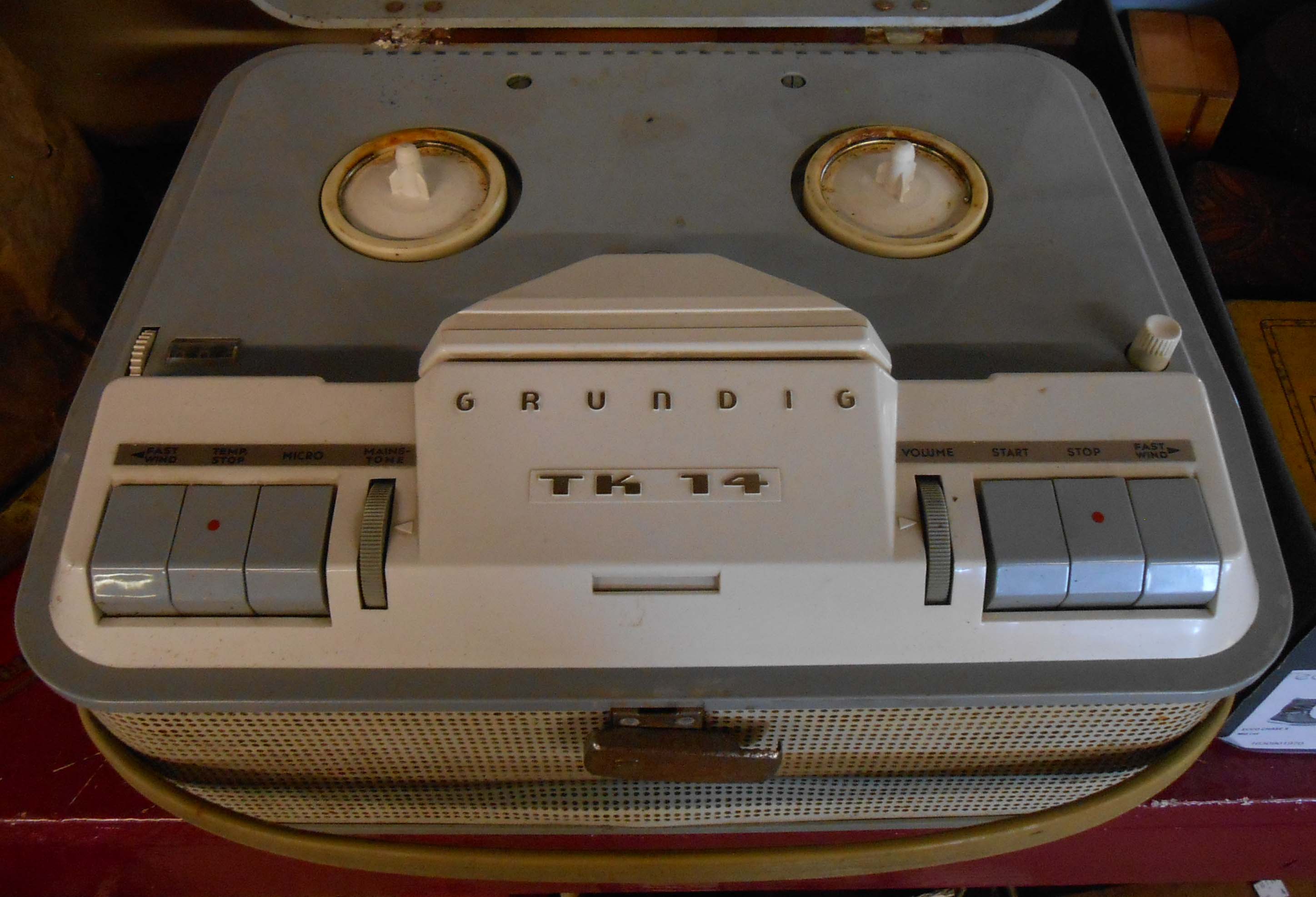 A vintage Grundig TK14 reel-to-reel tape recorder and tape reel can