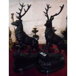 A pair of modern bronze stag figures on a grassy mound set on marble plinths - signature to base