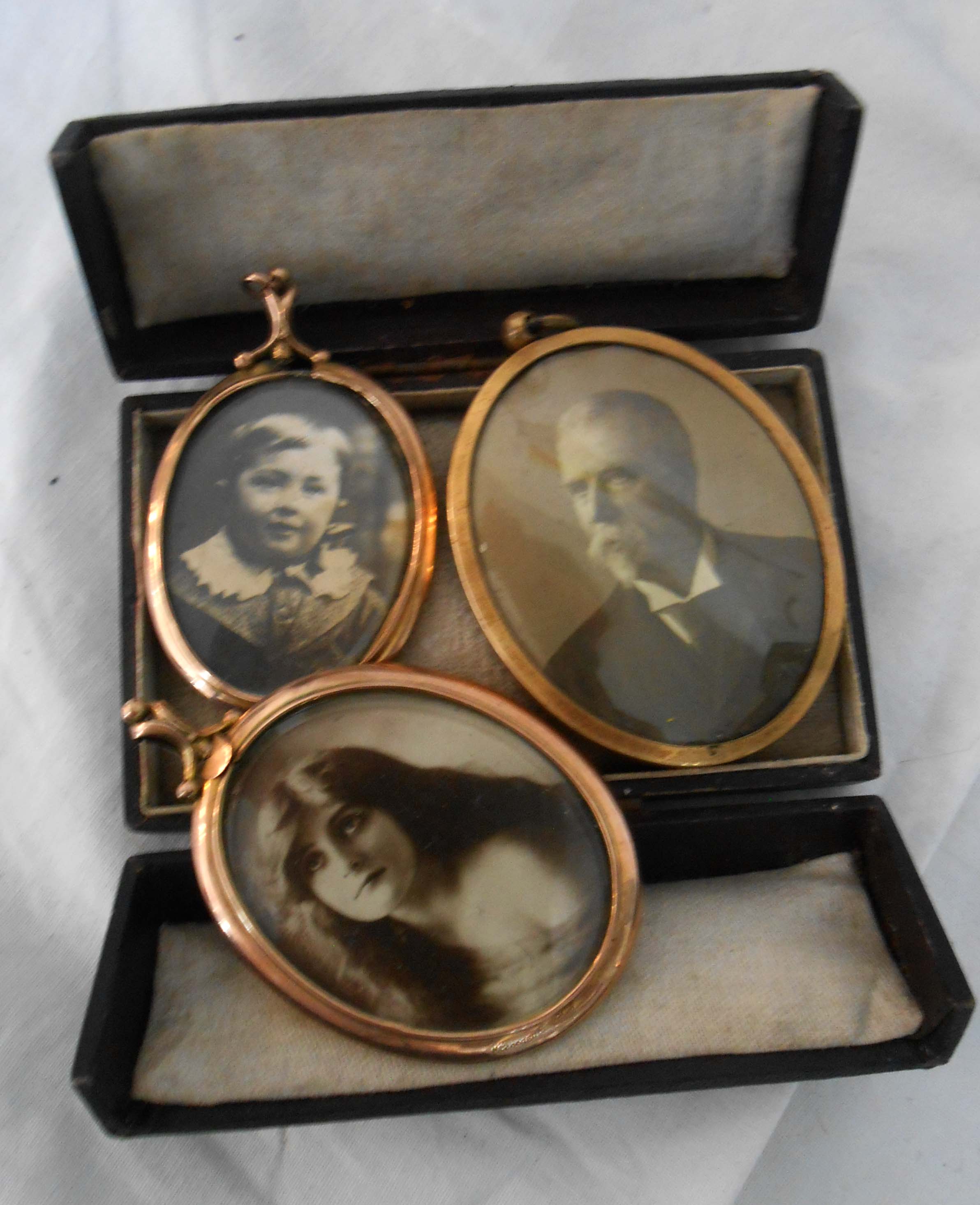 Three yellow metal framed photographic portraits and a leather clad folding case