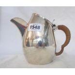 A silver hot water jug with sloping hinged lid, cane bound handle and 1939 New Forest motif, by