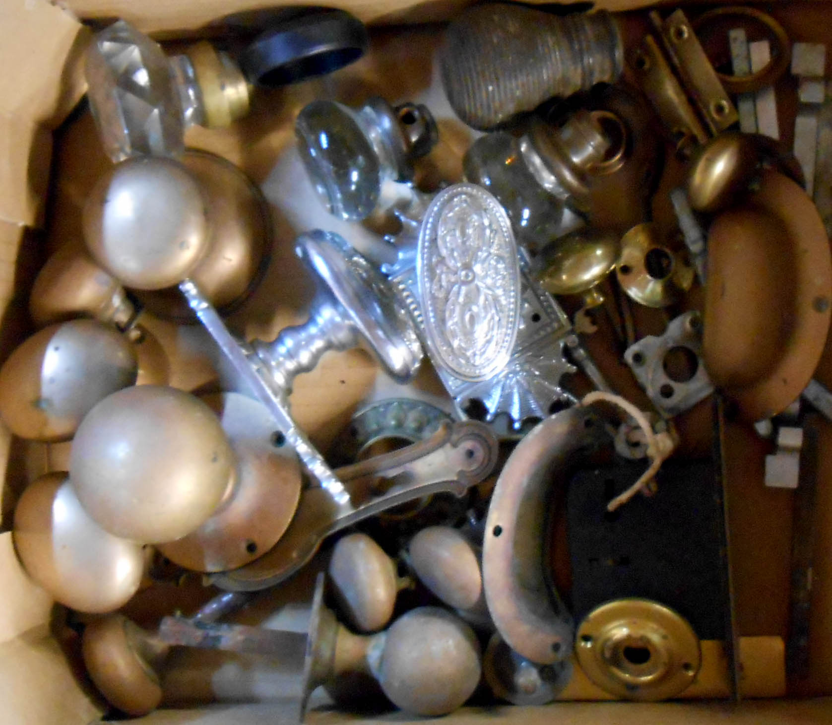 A box of assorted vintage door handles and fittings including glass, brass and chrome examples