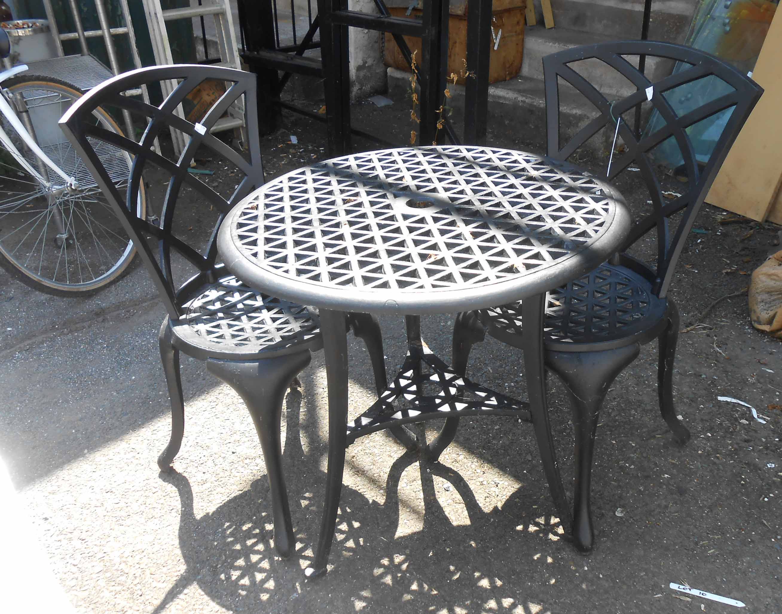 A black painted cast metal table with two chairs - paint flaking