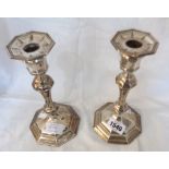 A pair of silver candlesticks with detachable nozzles and loaded octagonal bases by William Hutton &