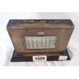 A vintage silver fronted desk calendar with engine turned decoration and painted wood base