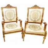 A pair of 19th Century ornate giltwood framed open armchairs with decorative top rails and