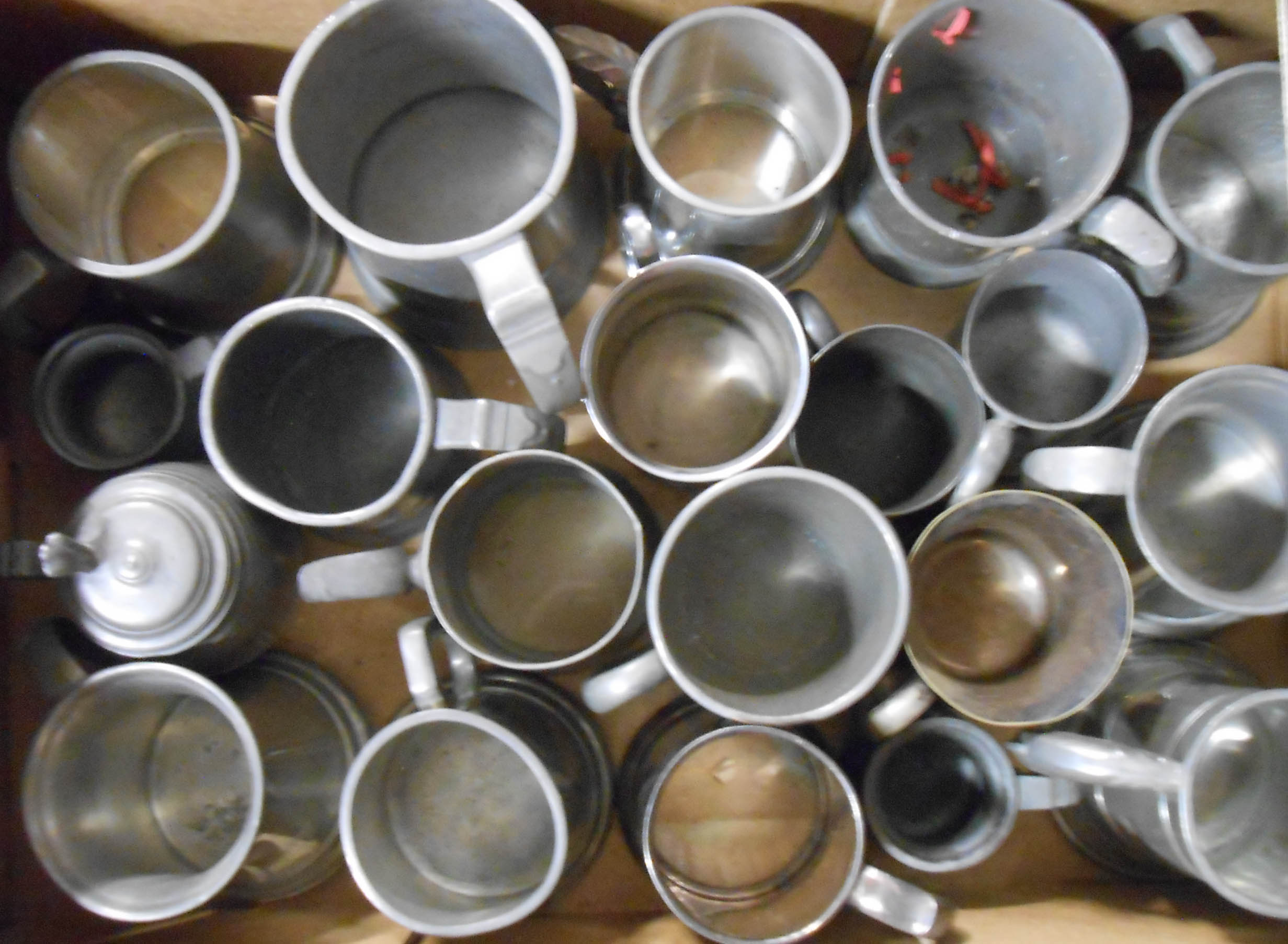A box containing a quantity of pewter and other tankards