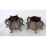 A pair of early 20th Century Chinese hallmarked silver salts of faceted design with all round dragon