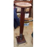 A torchere formed from an antique tester post, set on a square plinth base with brass lion paw feet