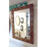 A stained pine framed oblong wall mirror with applied spiral boss decoration