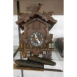 A small vintage stained wood cased cuckoo wall clock with twin pine cone pattern weight driven