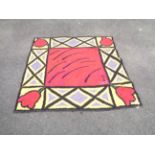 A handmade modern rug with tulip decoration to corners in bright vibrant colours - dated 1999