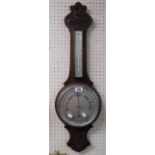 An early 20th Century carved oak cased banjo barometer/thermometer with aneroid works