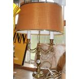 A cast brass table lamp in the form of a twin branch candelabra - with shade