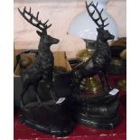 A pair of modern bronze stag figures on a grassy mound set on marble plinths - signature to base