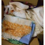 A small box containing assorted textiles and linen including tray cloths, placemats, etc.