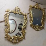 A pair of reproduction Rococo style gilt framed ornate wall mirrors with shaped plates