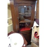 An 82cm vintage oak corner cabinet with glazed top and panelled door under