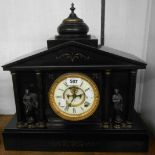 A late Victorian black slate cased mantel clock of architectural design with flanking pillars and