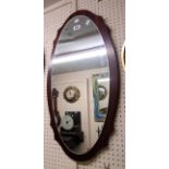 A retro style stained wood mounted oval wall mirror