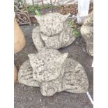 A pair of concrete garden gatekeeper statues each depicting an emerging ogre