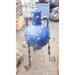 A blue glazed garden pot and lid in a wrought iron stand