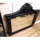 A modern ebonised framed overmantel mirror in the antique style with ornate pediment and oblong