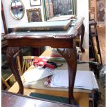 A reproduction mahogany coffee table with green leather under glass insert top, set on cabriole legs