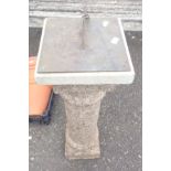 A garden sundial with etched brass plate and nomen set on a faux granite reconstituted stone