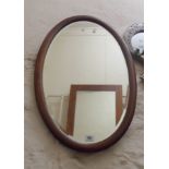 An Edwardian walnut and strung framed bevelled oval wall mirror