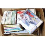 A box containing a quantity of Giles Cartoons annuals
