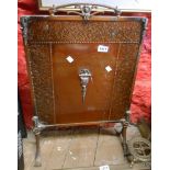 A coppered brass and iron fire screen with beaten effect decorative border and Rococo style handle