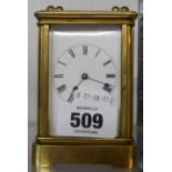 A small brass and bevelled glass cased carriage timepiece with Roman numerals and eight day