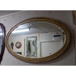 An early 20th Century gilt framed bevelled oval wall mirror