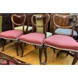 A set of six Victorian rosewood framed balloon back dining chairs with red machine tapestry