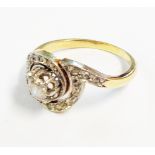 An old high carat yellow metal diamond encrusted swirl cross-over ring with central brilliant cut