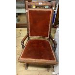 An antique American walnut framed rocking chair with unusual flexing bar action and upholstered back