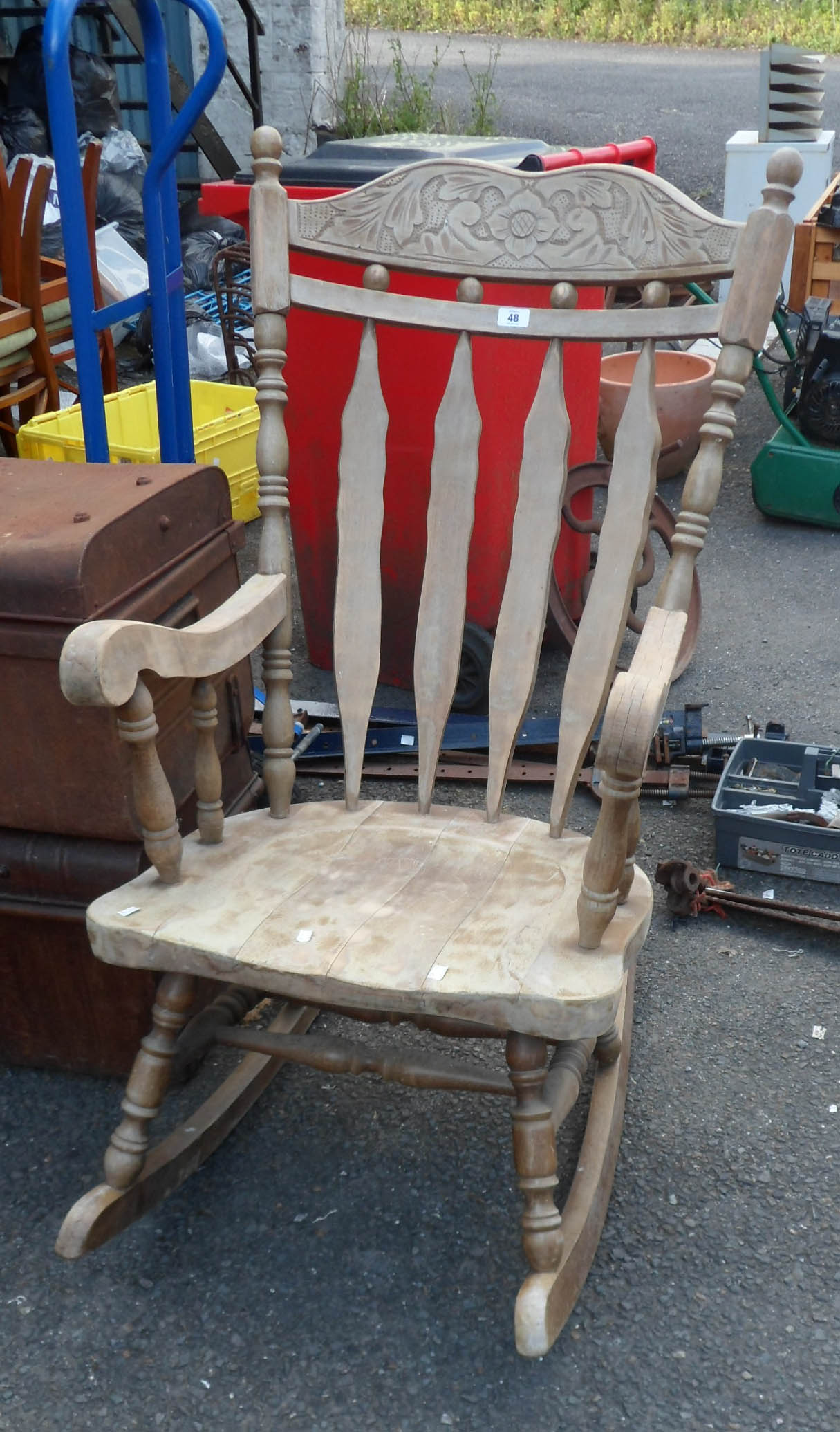 A wooden lathe back elbow rocking chair with carved decoration set on turned supports