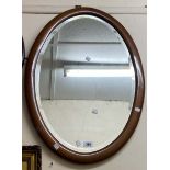 An Edwardian walnut framed bevelled oval wall mirror