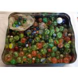 A tin containing a large quantity of vintage marbles