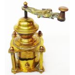 An antique brass coffee grinder of pergoda form with cast brass handle depicting a maiden riding a