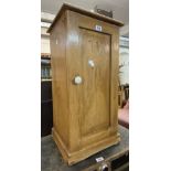 A Victorian waxed pine pot cupboard with panelled door and plinth base