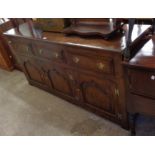 A 1.67m oak dresser base in the Georgian style with three frieze drawers and triple cupboard doors