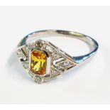 A marked PLAT Art Deco style pierced panel ring, set with central yellow sapphire and eight small