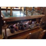 A 1.07m stained mixed wood coffee table with bevelled glass inset top, turned supports and