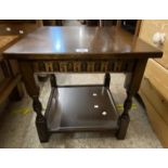 A 20th Century oak effect two tier tea table with turned supports